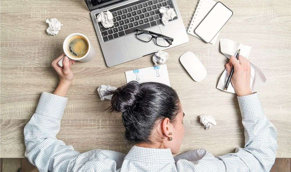 Worked sleeping at a messy desk.